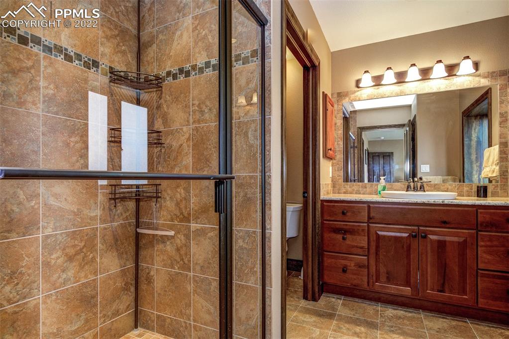6453 Reno Road Pueblo, CO 81004 - Photo 32 of 36 a bathroom with a double vanity sink and a mirror