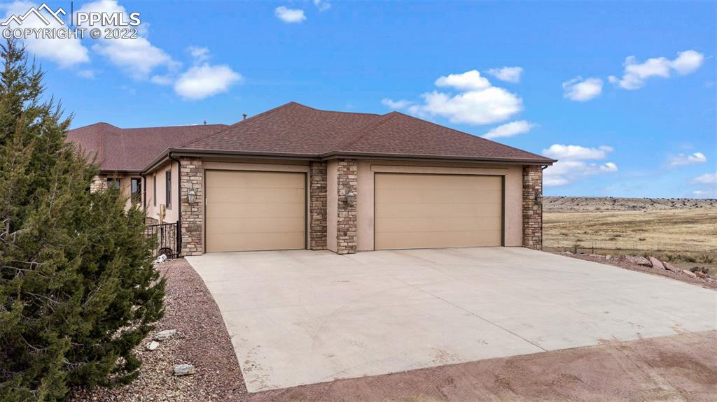 6453 Reno Road Pueblo, CO 81004 - Photo 9 of 36 a front view of a house with a yard and garage