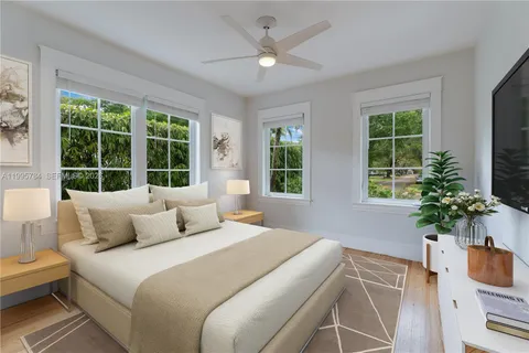 a bedroom with a large bed and a potted plant