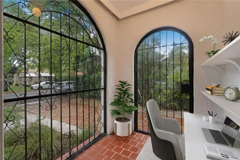 a view of a balcony with chairs and a potted plant