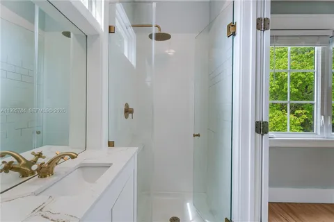 a bathroom with a sink a shower and a mirror