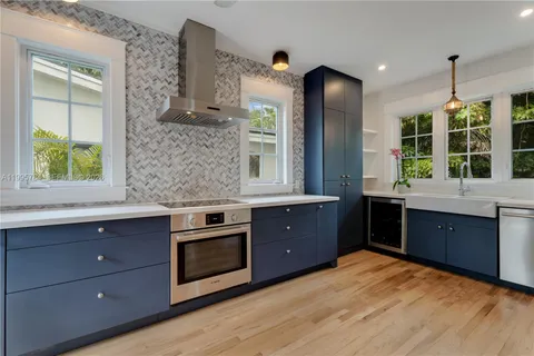 a kitchen with stainless steel appliances granite countertop a stove a sink and a wooden floors