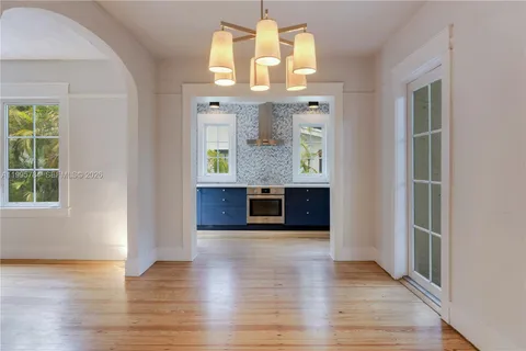 an open kitchen with granite countertop a stove and a wooden floors