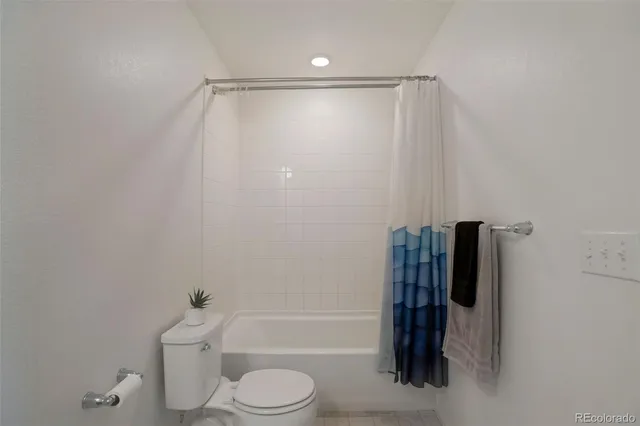 a bathroom with a shower a toilet and a tub