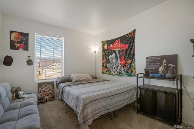 a bedroom with a bed and wall painting on the wall