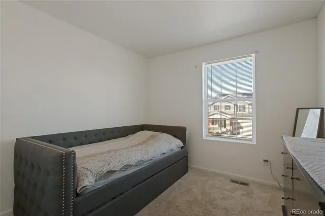 a bed sitting in a bedroom next to a window