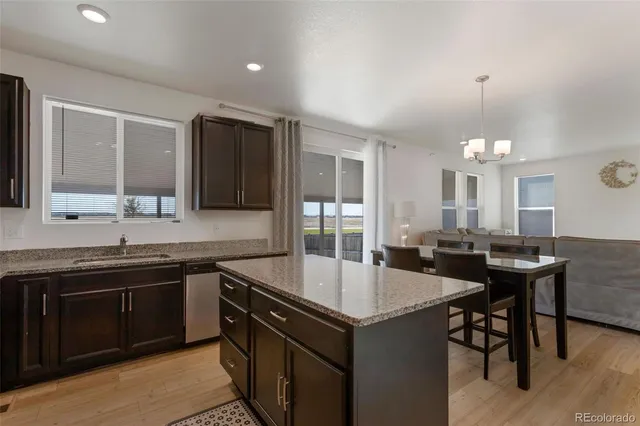 a kitchen with a sink a stove a dining table and chairs
