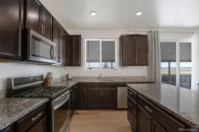 a kitchen with stainless steel appliances granite countertop a sink stove and cabinets