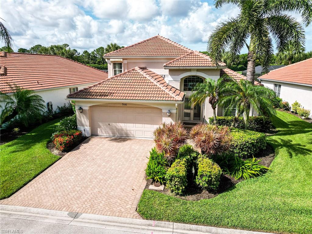 9156 Spring Run Boulevard Estero, FL 34135 - Photo 33 of 34 a front view of a house with garden