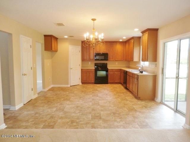801 Crystal Spring Way St. Augustine, FL 32092 - Photo 13 of 15 a large white kitchen with kitchen island a sink a stove a refrigerator and a refrigerator
