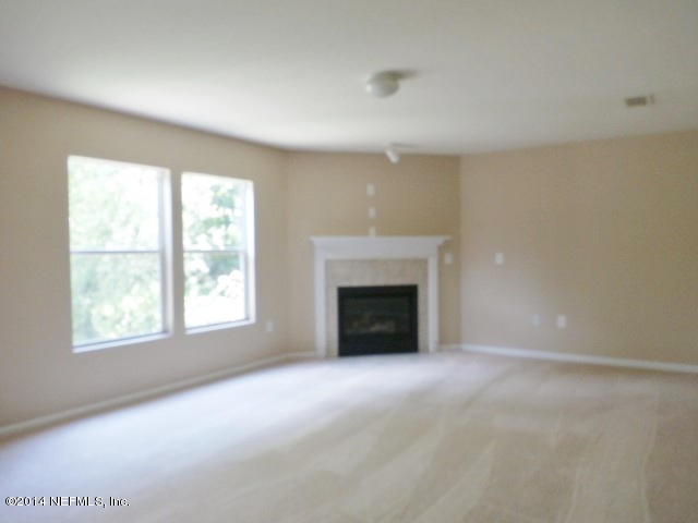 801 Crystal Spring Way St. Augustine, FL 32092 - Photo 10 of 15 an empty room with windows and fireplace
