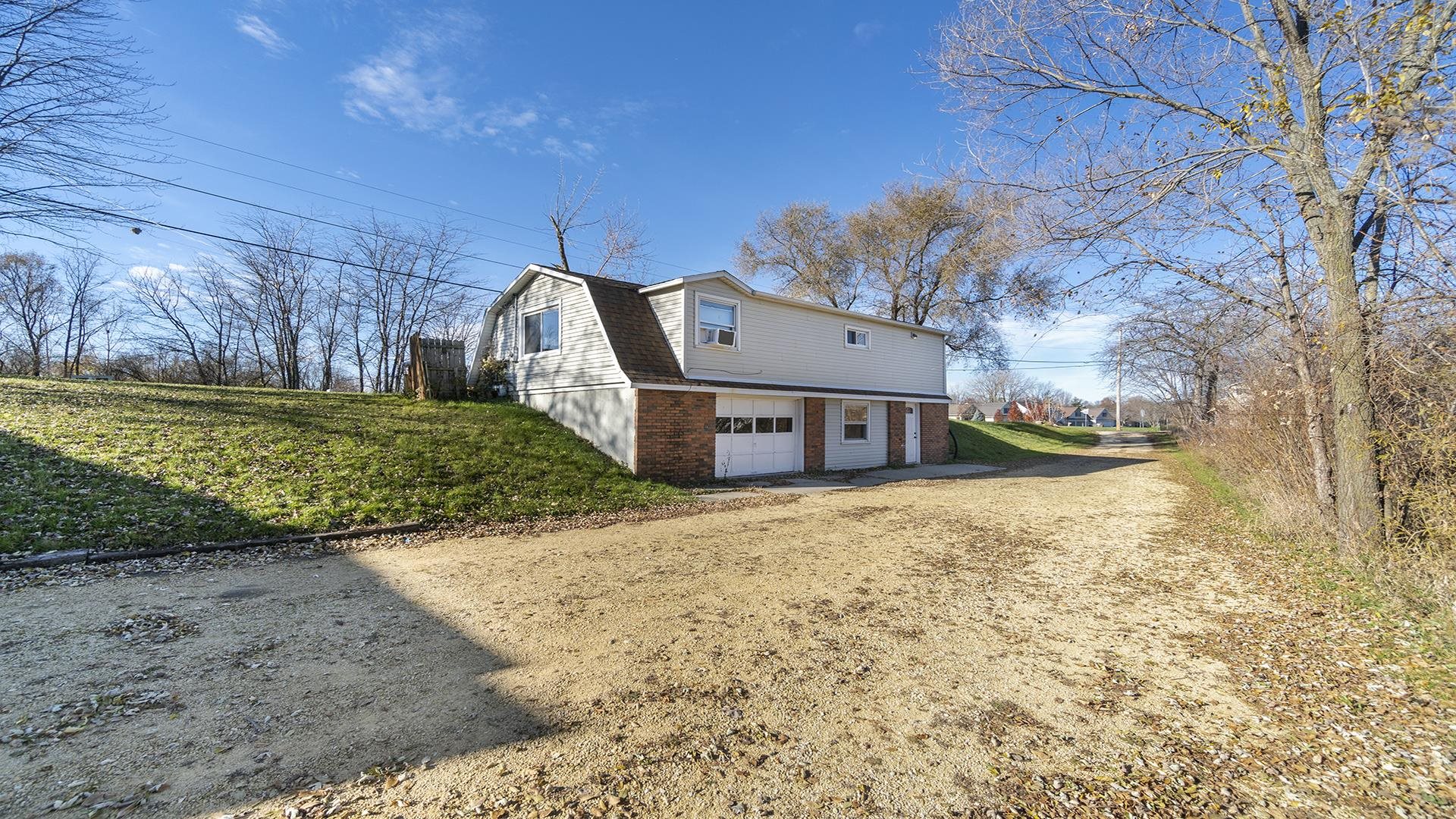3702 Genoa Road Cherry Valley, IL 61016 - Photo 3 of 17 a front view of a house with a yard