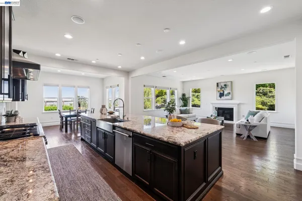 a living room with furniture kitchen view and a large window