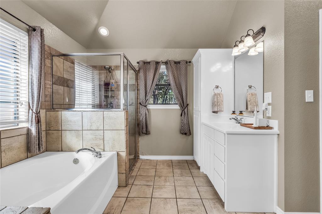 226 King George Road Ponder, TX 76259 - Photo 27 of 39 Bathroom featuring vanity, a textured wall, light tile patterned floors, a bath, and a shower stall