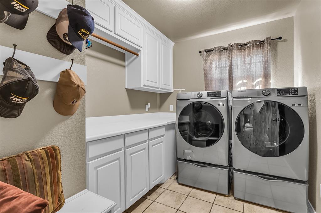 226 King George Road Ponder, TX 76259 - Photo 35 of 39 Laundry room with light tile patterned floors, a textured wall, washer and clothes dryer, a textured ceiling, and cabinet space