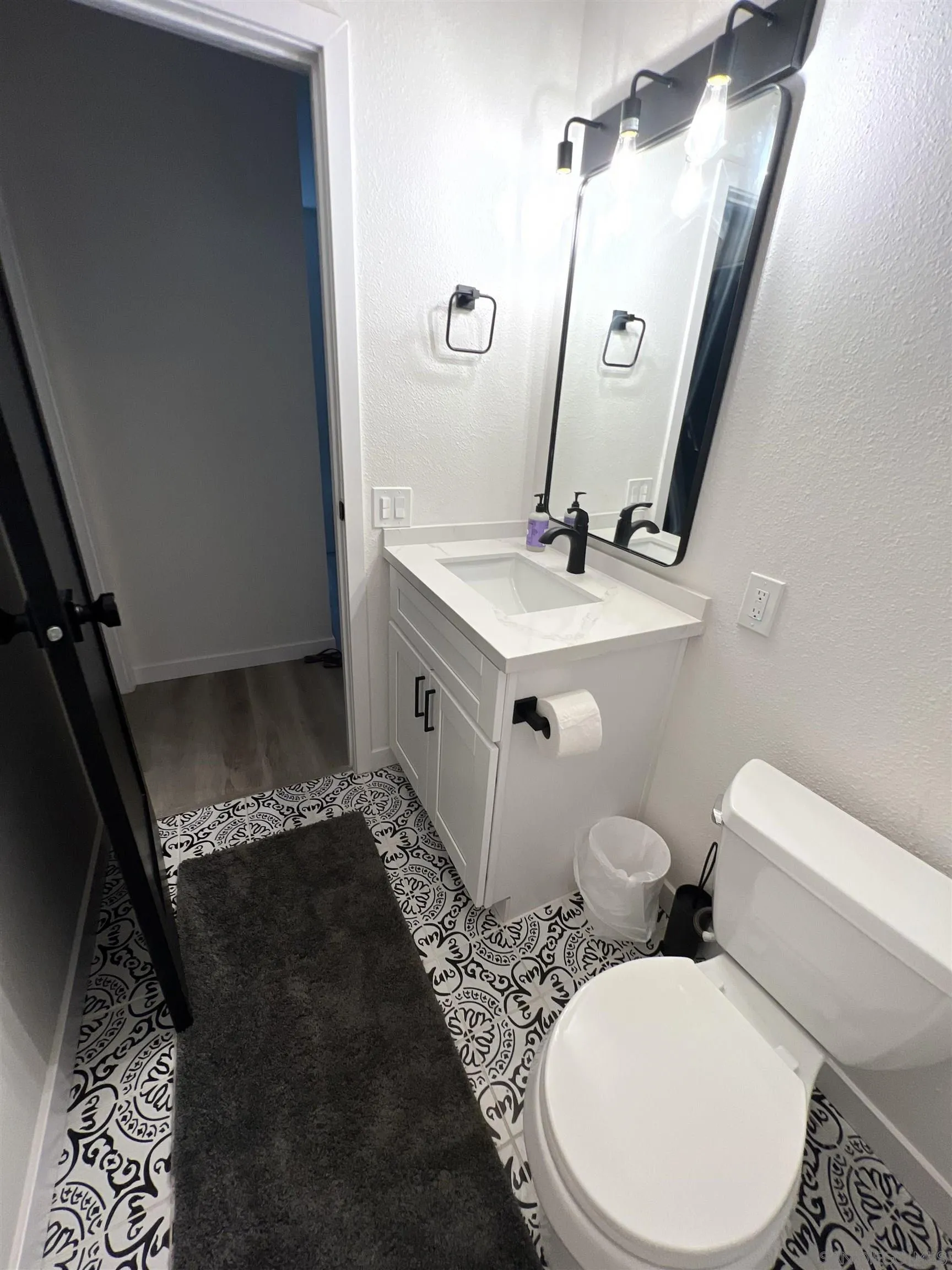 5462 Adobe Falls Road, Unit 11 San Diego, CA 92120 - Photo 13 of 19 a bathroom with a sink a toilet and mirror