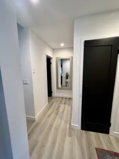 a view of a hallway with wooden floor and closet