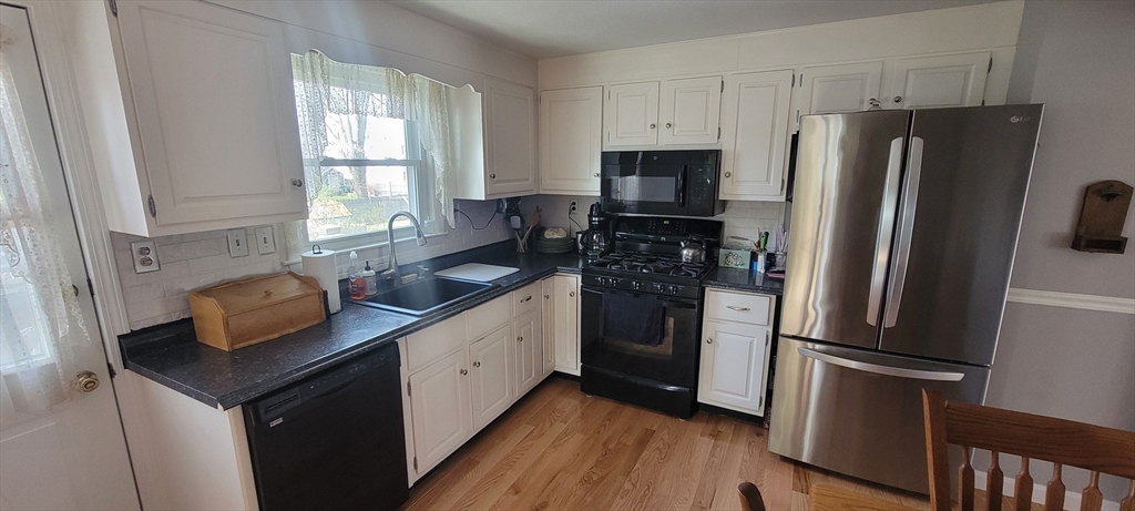 35 Park Avenue Reading, MA 01867 - Photo 4 of 15 a kitchen with stainless steel appliances a refrigerator a sink a stove a microwave and island