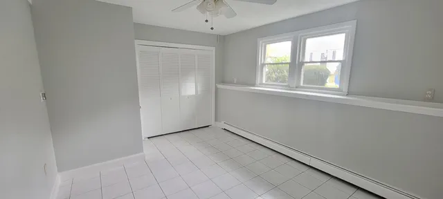 an empty room with windows and chandelier fan