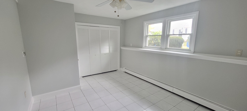 35 Park Avenue Reading, MA 01867 - Photo 9 of 15 an empty room with windows and chandelier fan