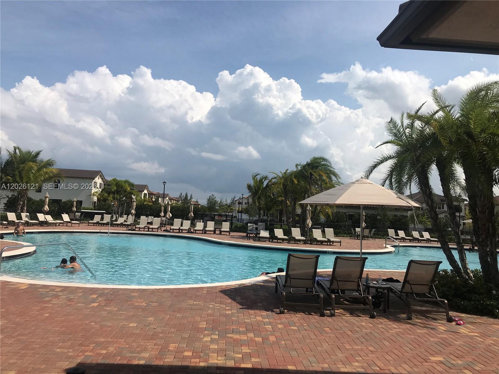 9307 West 33rd Way Hialeah, FL 33018 - Photo 22 of 23 a view of a table and chairs under an umbrella