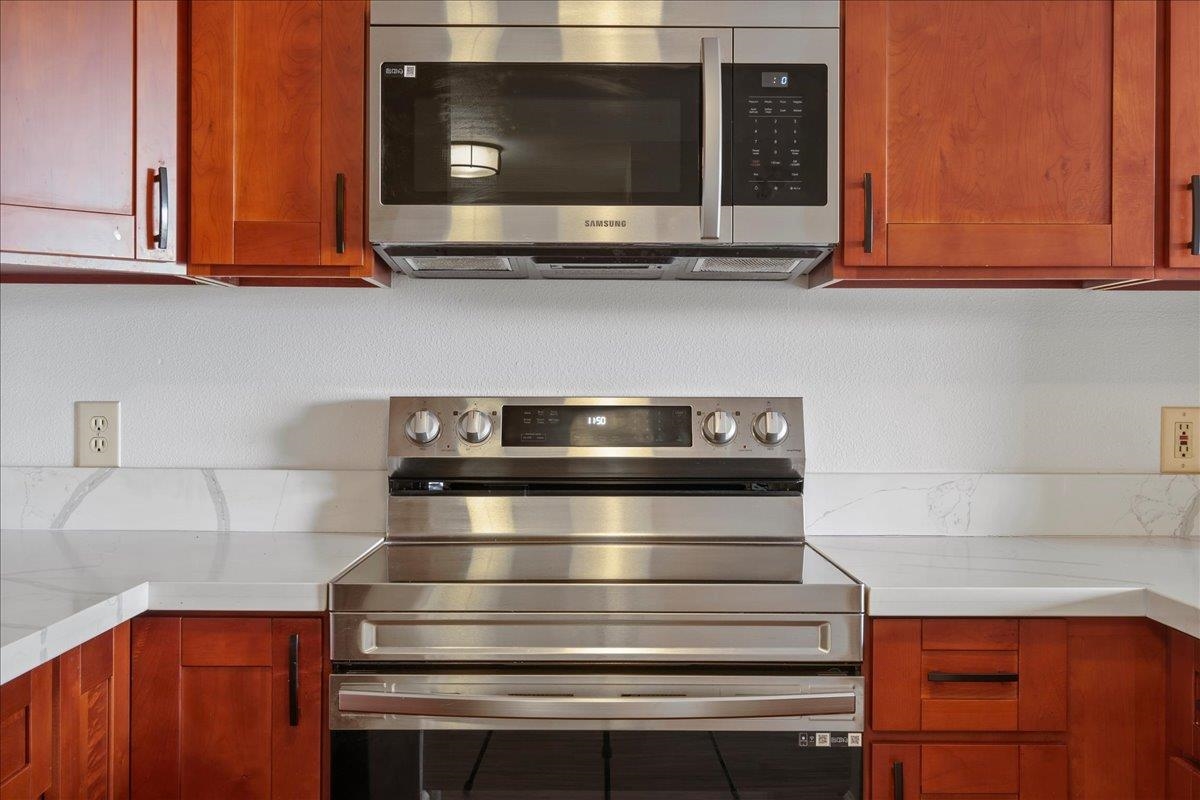 2747 South Kihei Road, Unit A107 Kihei, HI 96753 - Photo 18 of 46 a kitchen with stainless steel appliances granite countertop white cabinets and a microwave oven