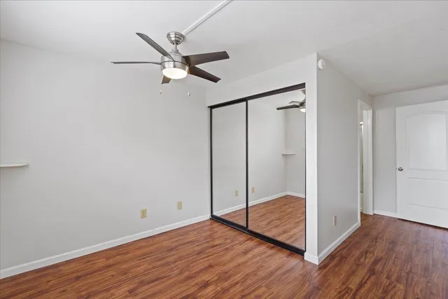 a view of a hallway with wooden floor and closet