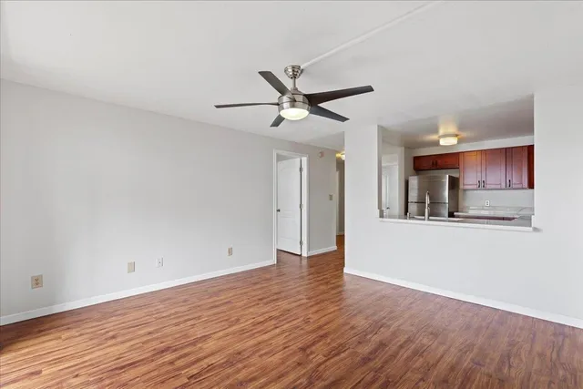 a view of an empty room with window and wooden floor
