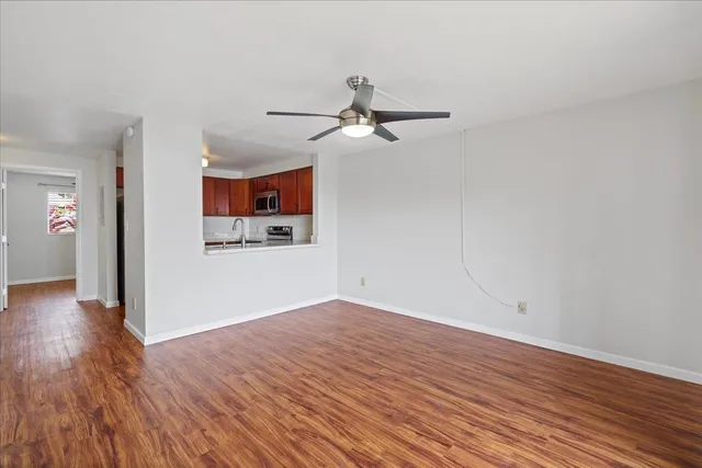 a view of a room with wooden floor and ceiling fan