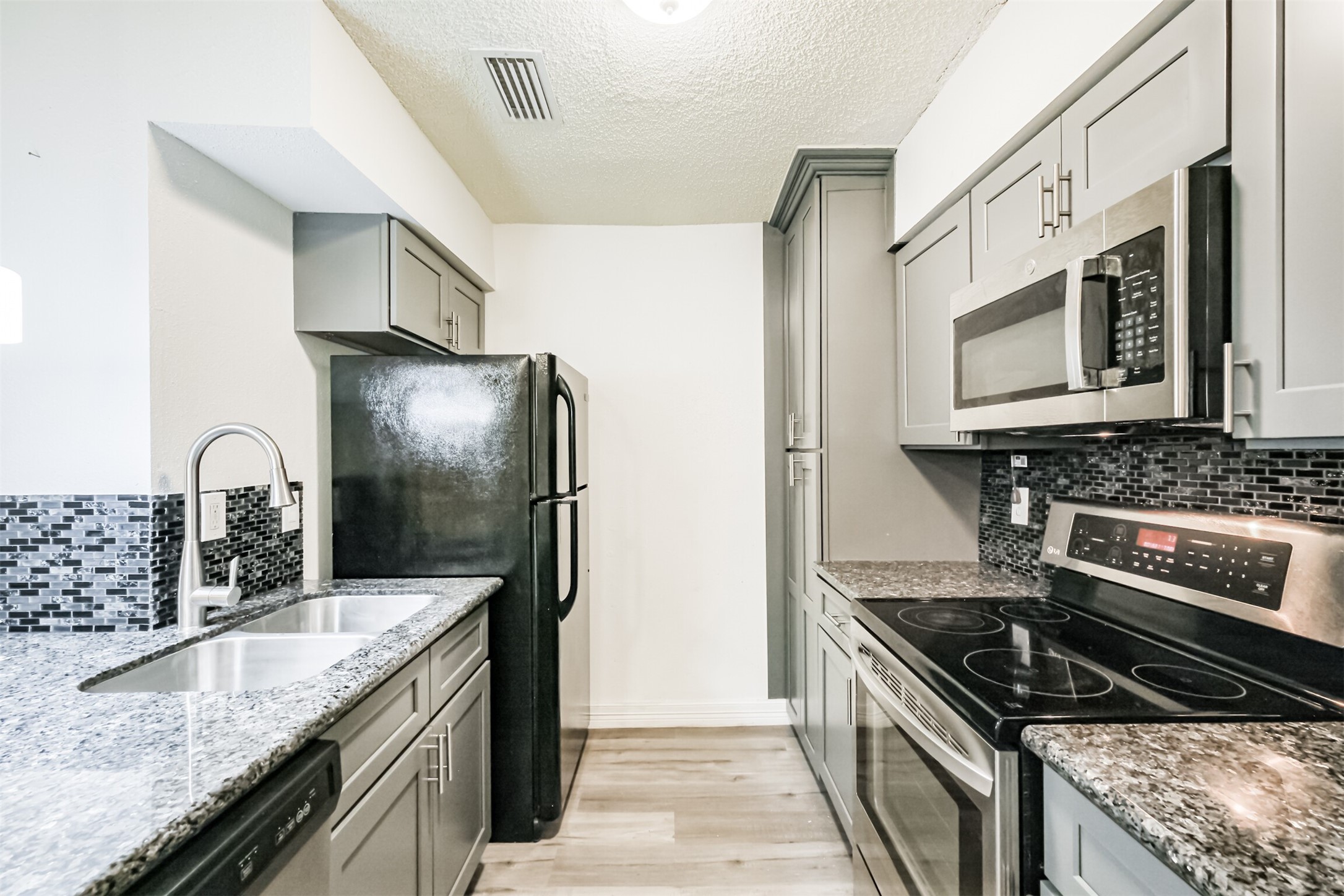 3100 Jeanetta Street, Unit 1305 Houston, TX 77063 - Photo 5 of 21 a kitchen with stainless steel appliances granite countertop a sink stove and refrigerator