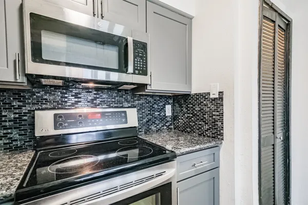 a kitchen with stove top oven and microwave