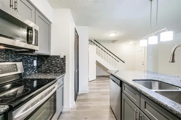 a kitchen with granite countertop a sink and steel stainless steel appliances