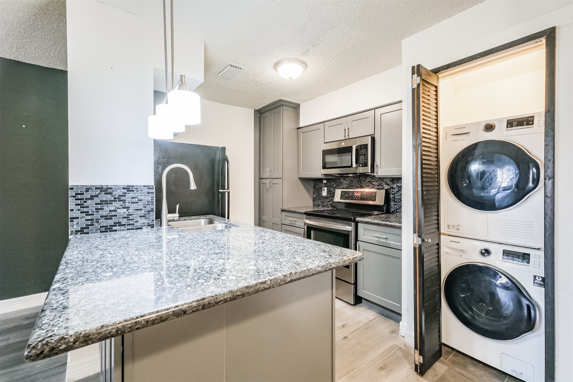 3100 Jeanetta Street, Unit 1305 Houston, TX 77063 - Photo 10 of 21 a kitchen with granite countertop a sink a stove and cabinets