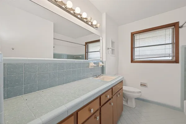 a bathroom with a sink a toilet and a mirror