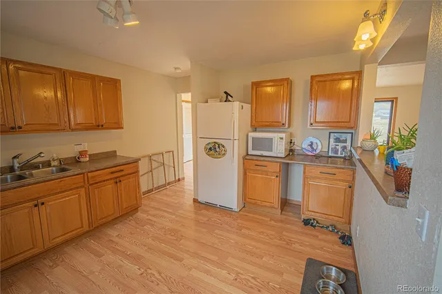 a kitchen with a sink refrigerator and cabinets