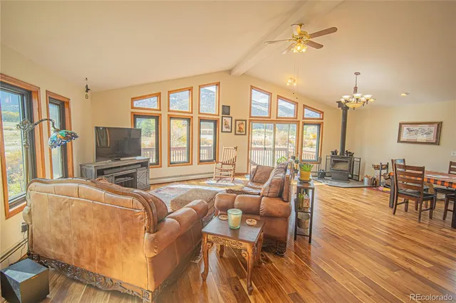 a living room with furniture a flat screen tv and a floor to ceiling window