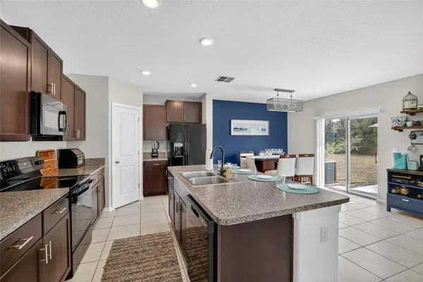 a kitchen with a dining table chairs and refrigerator