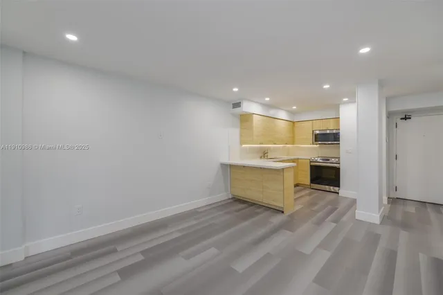 a large kitchen with a refrigerator and a stove top oven