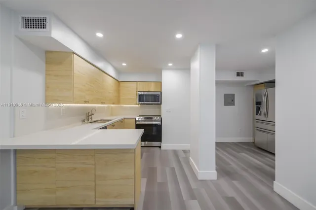 a kitchen with a sink stainless steel appliances and counter space