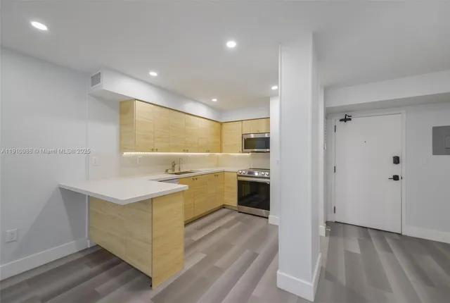 a kitchen with a sink wooden floor and stainless steel appliances