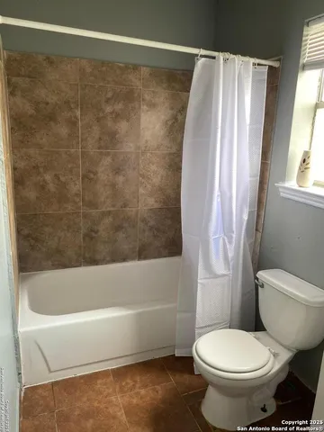 a bathroom with a toilet and a bathtub