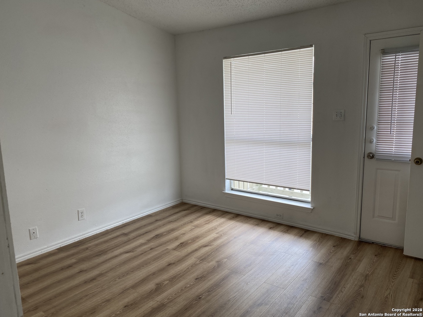 4949 Hamilton Wolfe Road, Unit 5201 San Antonio, TX 78229 - Photo 10 of 29 an empty room with wooden floor and windows