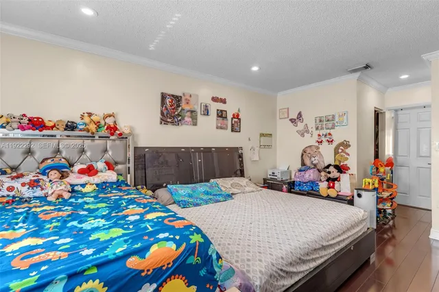 a bedroom with bed and wooden floor