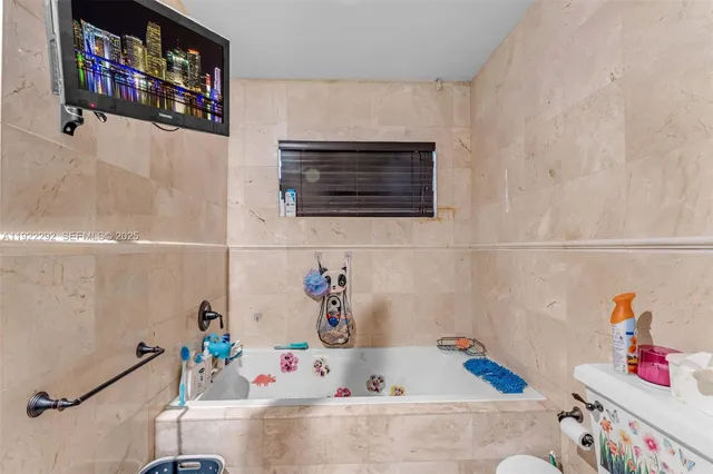 a bathroom with a tub a sink and a mirror