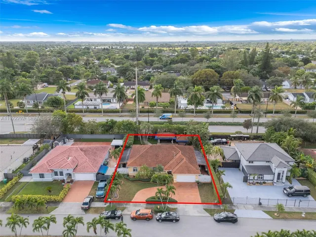 an aerial view of residential houses with outdoor space and ocean view