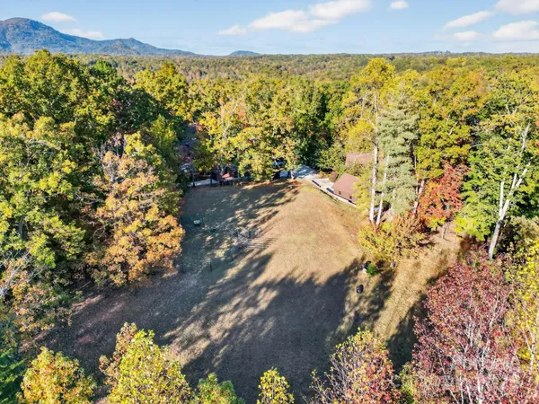 an aerial view of a house with large trees