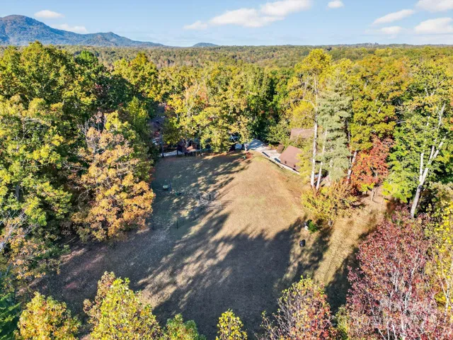 an aerial view of a house with large trees