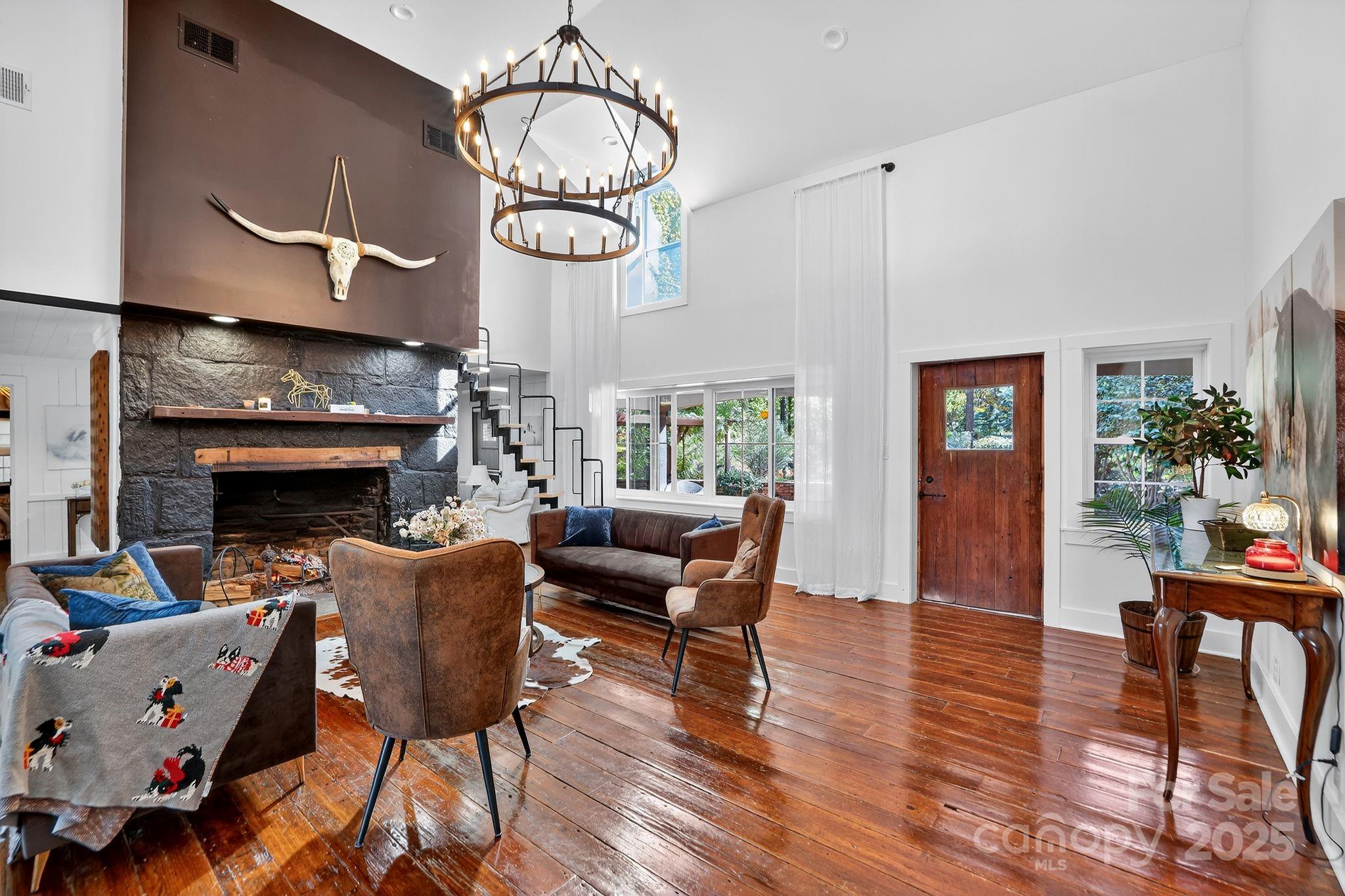 777 South River Road Tryon, NC 28782 - Photo 18 of 42 a living room with furniture chandelier and a fireplace