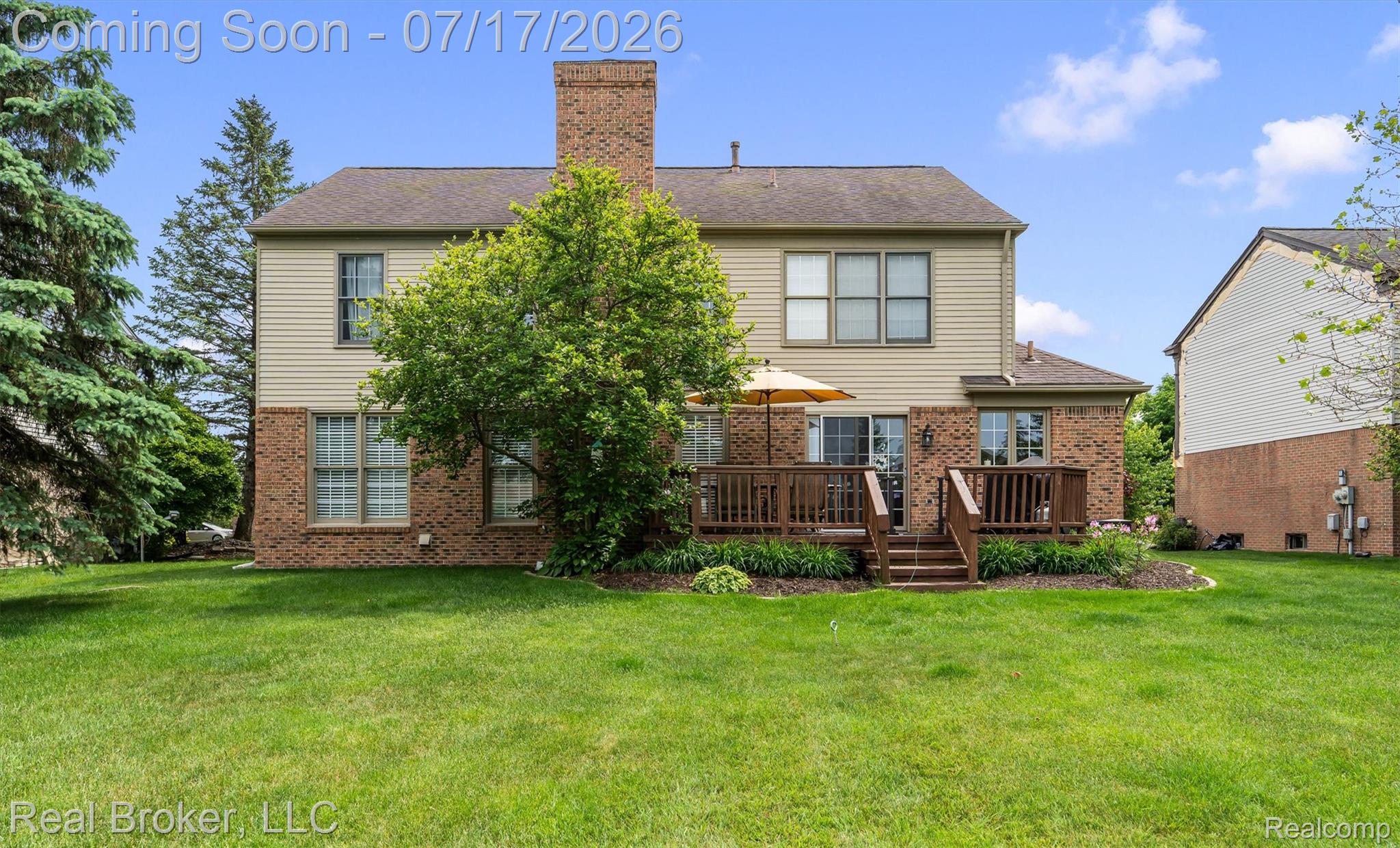 45192 Thornhill Road Canton, MI 48188 - Photo 29 of 34 Rear elevation featuring a multi-level wood deck, brick and siding exterior, multiple windows, and a prominent brick chimney