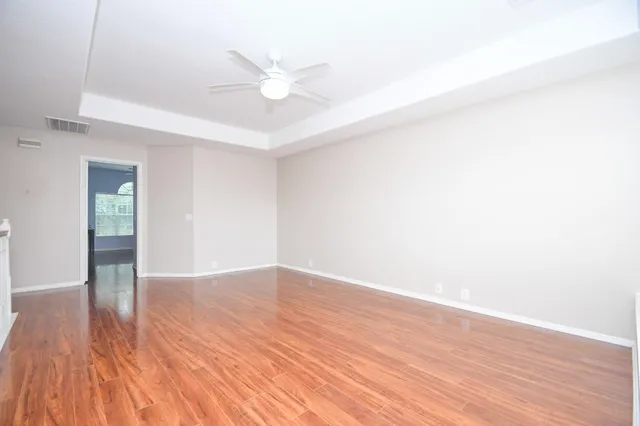 a view of an empty room with wooden floor